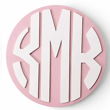 Monogrammed coasters in various color combinations on a white background