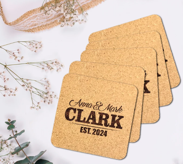 Set of cork coasters with 'Anna & Mark Clark Est. 2024' text on a light background.