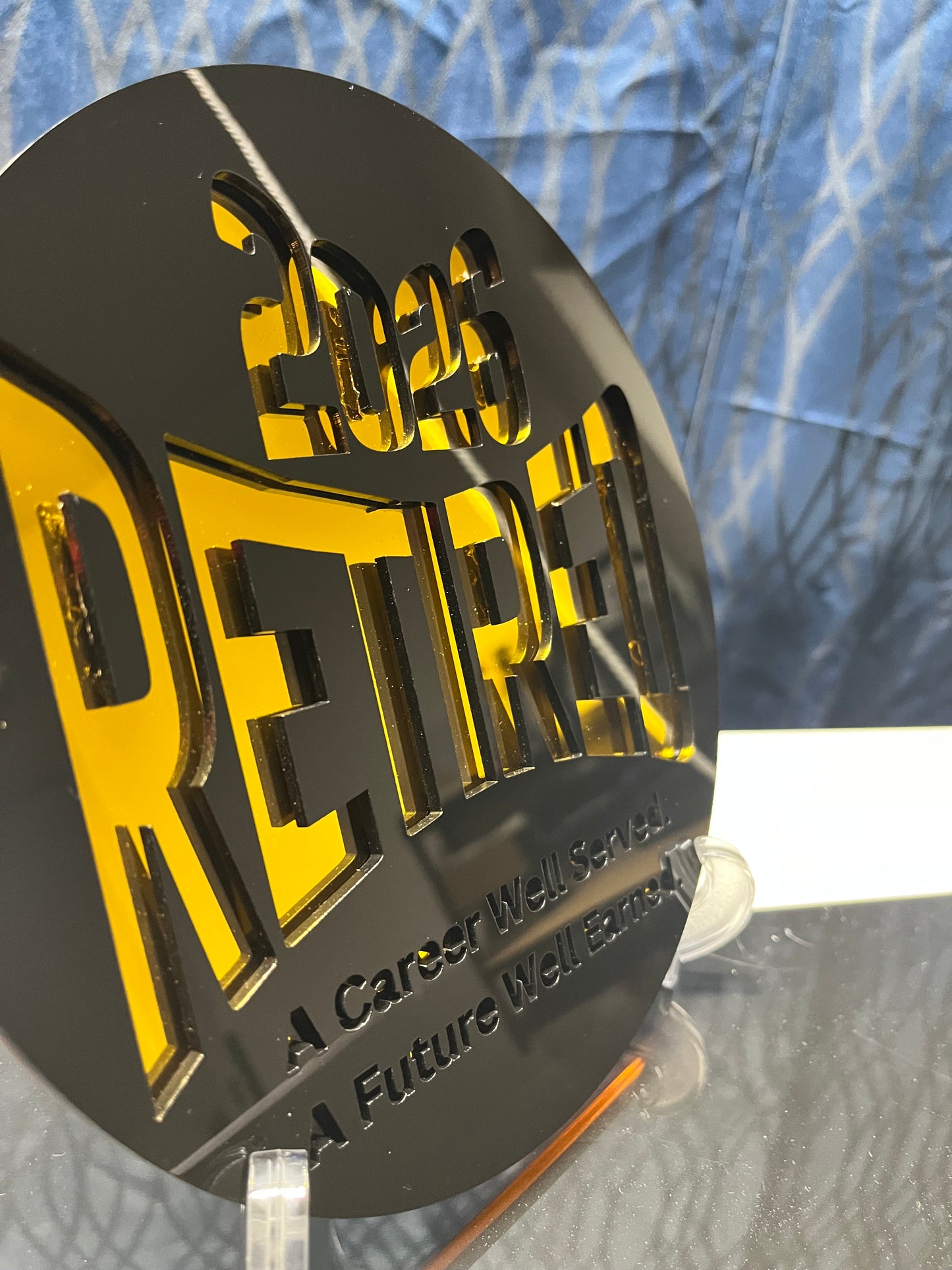 Metallic gold and black retirement sign with text on a textured surface