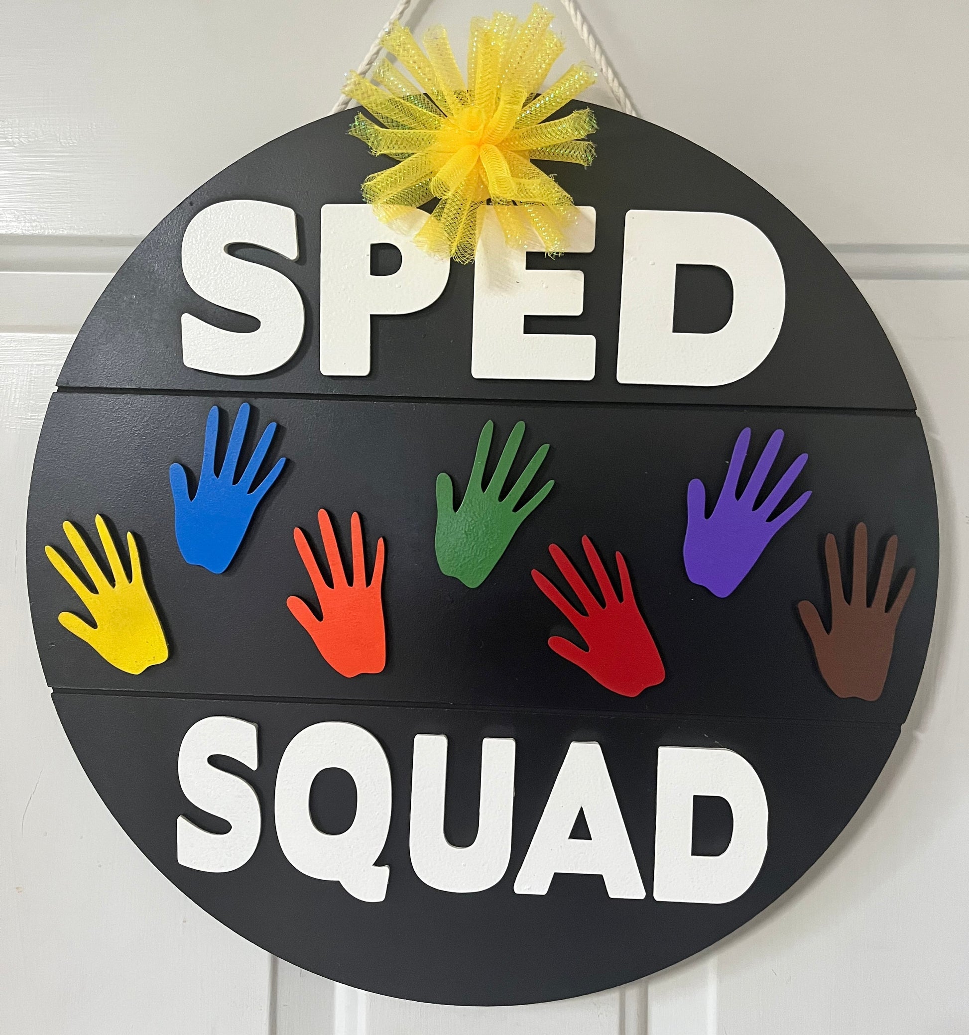 SPED Squad finished painted sign with rainbow hands on classroom door