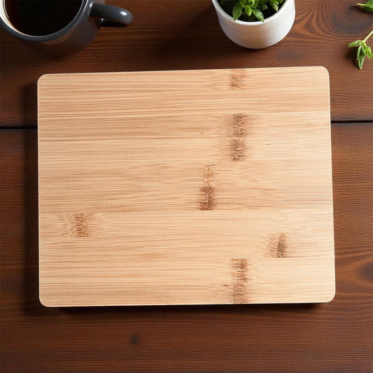 Wooden cutting board on a wooden surface with a cup and plant in the background