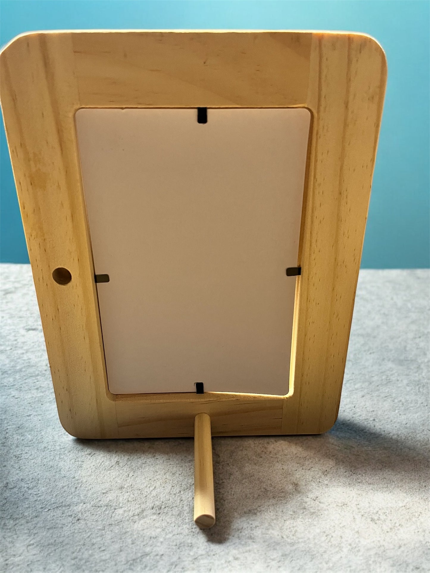 Wooden picture frame with a white mat on a gray surface