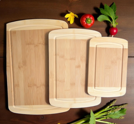 Set of three bamboo cutting boards on a wooden surface with vegetables.