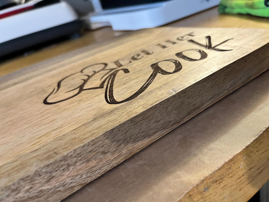 Wooden cutting board with engraved text on a wooden surface