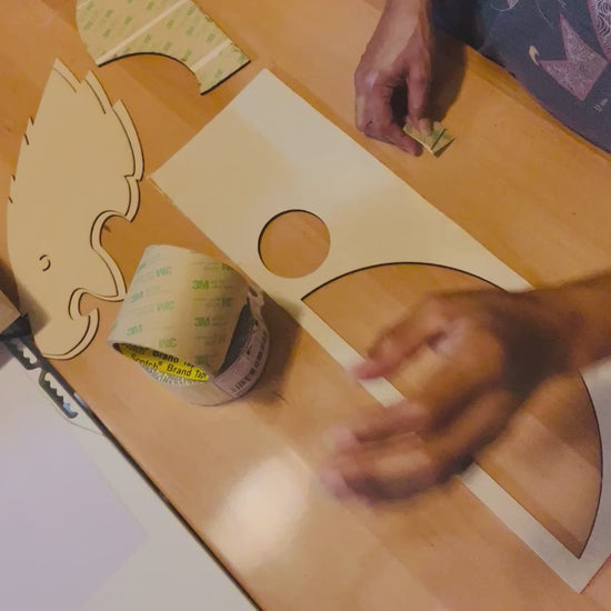 Person Adding 3M Adhesive to the back of Wood to show how it works