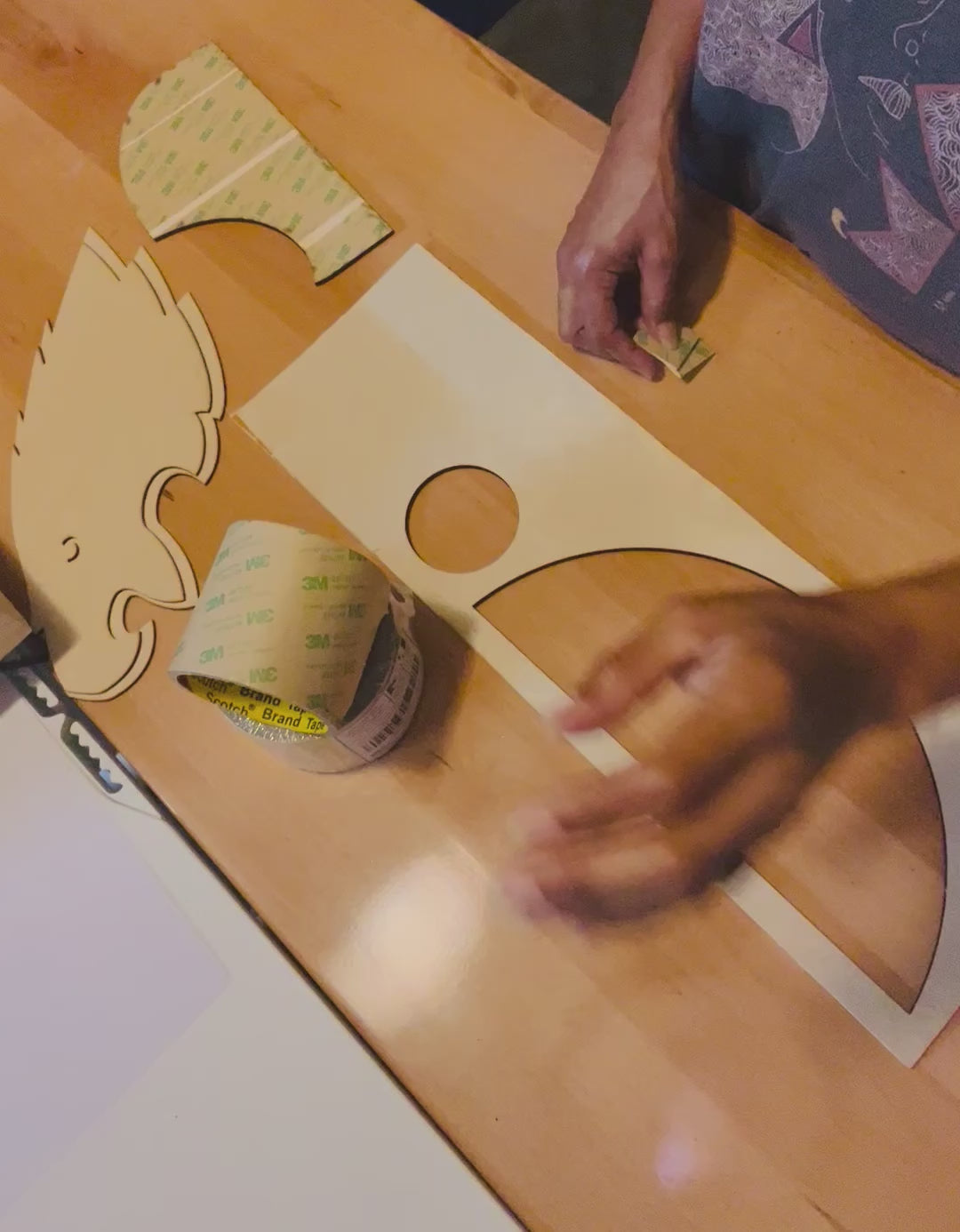Person Adding 3M Adhesive to the back of Wood to show how it works